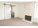 Living room with fireplace, carpet, and sliding barn door leading to the bathroom at 8101 Spur Ct, Las Vegas, NV 89145