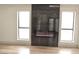Bright living room showcasing modern fireplace and two windows with hardwood flooring at 8101 Spur Ct, Las Vegas, NV 89145