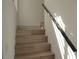 Modern staircase with wood-grain steps and a sleek dark railing, blending style and functionality at 8101 Spur Ct, Las Vegas, NV 89145