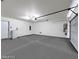 Spacious garage interior with gray floors, white walls and door to home for added convenience at 9050 W Tropicana Ave # 1009, Las Vegas, NV 89147