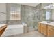 Bright bathroom offers a soaking tub and glass enclosed shower at 10200 Clark Wooldridge Ct, Las Vegas, NV 89129