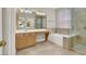 Bright bathroom with dual sinks, a tub, and a glass enclosed shower at 10200 Clark Wooldridge Ct, Las Vegas, NV 89129