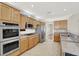 Bright kitchen showcases tile flooring, wood cabinetry, stainless steel appliances, and granite countertops at 10200 Clark Wooldridge Ct, Las Vegas, NV 89129