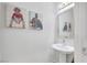 Chic half-bathroom with a pedestal sink, decorative mirror, and unique wall art for a modern touch at 1180 Solano Hills Ct, Henderson, NV 89002