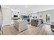 Bright kitchen area with stainless appliances and a granite island flows into the living room with large windows at 1180 Solano Hills Ct, Henderson, NV 89002