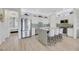 Well-lit kitchen with a large granite island, stainless steel refrigerator, and adjacent bedroom at 1180 Solano Hills Ct, Henderson, NV 89002
