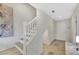 Inviting staircase with white banisters, patterned wallpaper, and warm-toned flooring leading to the upper level at 1180 Solano Hills Ct, Henderson, NV 89002