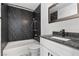 Modern bathroom featuring bold dark granite, a sleek vanity, and a convenient bathtub-shower combination at 1403 Bareback Ct, Henderson, NV 89014