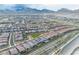 Birds-eye view of a residential community showcasing houses with pools and a manicured green space, set against a mountain backdrop at 154 Nine Mile Creek Dr, Las Vegas, NV 89138
