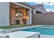 Covered patio with cooking station, built-in grill, mini-refrigerator and outdoor television, and swimming pool at 154 Nine Mile Creek Dr, Las Vegas, NV 89138