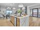 A modern, open-concept kitchen featuring a waterfall island, wine storage, and bright lighting at 154 Nine Mile Creek Dr, Las Vegas, NV 89138