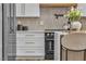 Modern kitchen with stainless steel refrigerator and appliances, white cabinets, and a kitchen island with chairs at 154 Nine Mile Creek Dr, Las Vegas, NV 89138