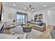 An open-concept living room with modern furniture, a ceiling fan, and sliding glass doors to the backyard at 154 Nine Mile Creek Dr, Las Vegas, NV 89138