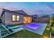 Backyard pool with lounge chairs, artificial grass and covered patio with cooking station and TV at 154 Nine Mile Creek Dr, Las Vegas, NV 89138