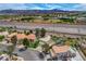 An aerial view of a neighborhood featuring houses, green landscaping, freeway access, and mountain views at 2073 Sapphire Valley Ave, Henderson, NV 89074