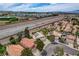 Aerial view of a neighborhood with solar panels and proximity to the freeway at 2073 Sapphire Valley Ave, Henderson, NV 89074