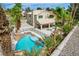Backyard features a pool with rock features, palm trees, lush landscaping, and outdoor space at 2073 Sapphire Valley Ave, Henderson, NV 89074