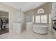 Bright bathroom with a free-standing tub, marble shower, and gray stone accent wall with a fireplace at 2073 Sapphire Valley Ave, Henderson, NV 89074