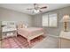 Bedroom featuring a light pink bed, patterned rug, and a window with plantation shutters at 2073 Sapphire Valley Ave, Henderson, NV 89074