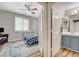 Cozy bedroom with hardwood floors, ceiling fan, and view into bathroom with blue vanity at 2073 Sapphire Valley Ave, Henderson, NV 89074