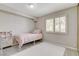 Bedroom featuring a light pink bed, neutral walls, and window with plantation shutters at 2073 Sapphire Valley Ave, Henderson, NV 89074