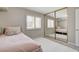 Bedroom featuring a light pink bed, neutral walls, mirrored closet doors, and white rug at 2073 Sapphire Valley Ave, Henderson, NV 89074
