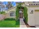 Inviting home featuring a lush green lawn, mature landscaping, and welcoming front door with climbing vines at 2073 Sapphire Valley Ave, Henderson, NV 89074