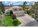 Lovely home with a two-car garage, well-manicured lawn, and desert landscaping on a sunny day at 2073 Sapphire Valley Ave, Henderson, NV 89074