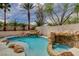 Backyard pool with rock waterfall feature surrounded by lush landscaping at 2073 Sapphire Valley Ave, Henderson, NV 89074
