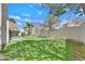 Large backyard with green grass, privacy wall, and mature trees offering shade and a tranquil outdoor space at 2324 Babcock Dr, Las Vegas, NV 89134