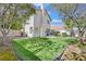 A spacious backyard features a lush lawn, shade trees, and a patio area, ideal for relaxation and outdoor activities at 2324 Babcock Dr, Las Vegas, NV 89134