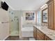 Full bath with a glass shower, soaking tub, shuttered window, and double vanity at 2324 Babcock Dr, Las Vegas, NV 89134