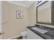 Updated powder room featuring dark granite countertops and decorative mirror at 2324 Babcock Dr, Las Vegas, NV 89134