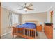 Bedroom with natural wood furniture set, ceiling fan, and shuttered window at 2324 Babcock Dr, Las Vegas, NV 89134