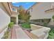 Beautifully landscaped front yard with lush green lawn and mature trees and brick walkway at 2324 Babcock Dr, Las Vegas, NV 89134