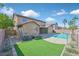 Large backyard with artificial turf, desert landscaping, and refreshing pool area with mountain views at 24 Painted View St, Henderson, NV 89012