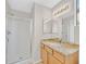 Well-lit bathroom featuring a granite countertop, wooden vanity, and glass enclosed shower at 24 Painted View St, Henderson, NV 89012