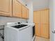 Laundry room with washer, dryer, and oak cabinets at 24 Painted View St, Henderson, NV 89012