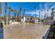 Spacious backyard with a pool, mature palm trees, and desert landscaping create a tropical oasis at 2685 S Tenaya Way, Las Vegas, NV 89117