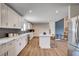 The kitchen features white cabinetry, stainless steel appliances, island with bar seating, and lots of light at 2685 S Tenaya Way, Las Vegas, NV 89117