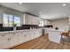 Sunlit kitchen boasts white cabinets, an island with bar seating, stainless steel appliances, and modern design at 2685 S Tenaya Way, Las Vegas, NV 89117