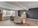 Open-plan living room showcases large windows, stylish chairs, and custom black accent wall at 2685 S Tenaya Way, Las Vegas, NV 89117