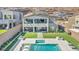 Aerial view of a backyard with a sparkling pool, lush green lawn, and a covered outdoor living space at 270 Shaded Canyon Dr, Henderson, NV 89012