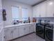 Well-organized laundry room with ample counter space, built-in cabinets, sink, and modern washer and dryer at 270 Shaded Canyon Dr, Henderson, NV 89012