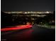 Night view showing the city skyline and bright city lights from atop a hill with some light trails on the road at 270 Shaded Canyon Dr, Henderson, NV 89012