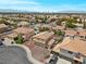 Aerial view of a desert suburban neighborhood with well-maintained homes, tile roofs, and mountain views at 2716 Timber Crossing Ct, Henderson, NV 89074