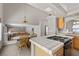 Open kitchen with a gas cooktop island, tile countertops, and a view of the dining area at 2716 Timber Crossing Ct, Henderson, NV 89074