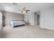 Large main bedroom with carpet, fan, and ensuite bathroom and closet entrances at 2716 Timber Crossing Ct, Henderson, NV 89074