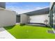Backyard with lush green turf, stone walkway, and modern architectural elements at 2787 La Bella Ct, Henderson, NV 89052