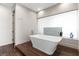 Modern bathroom with freestanding tub, wood-look tile floors, and large glass feature at 2787 La Bella Ct, Henderson, NV 89052